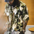 Person wearing a shirt with a nature-themed design featuring birds and foliage.